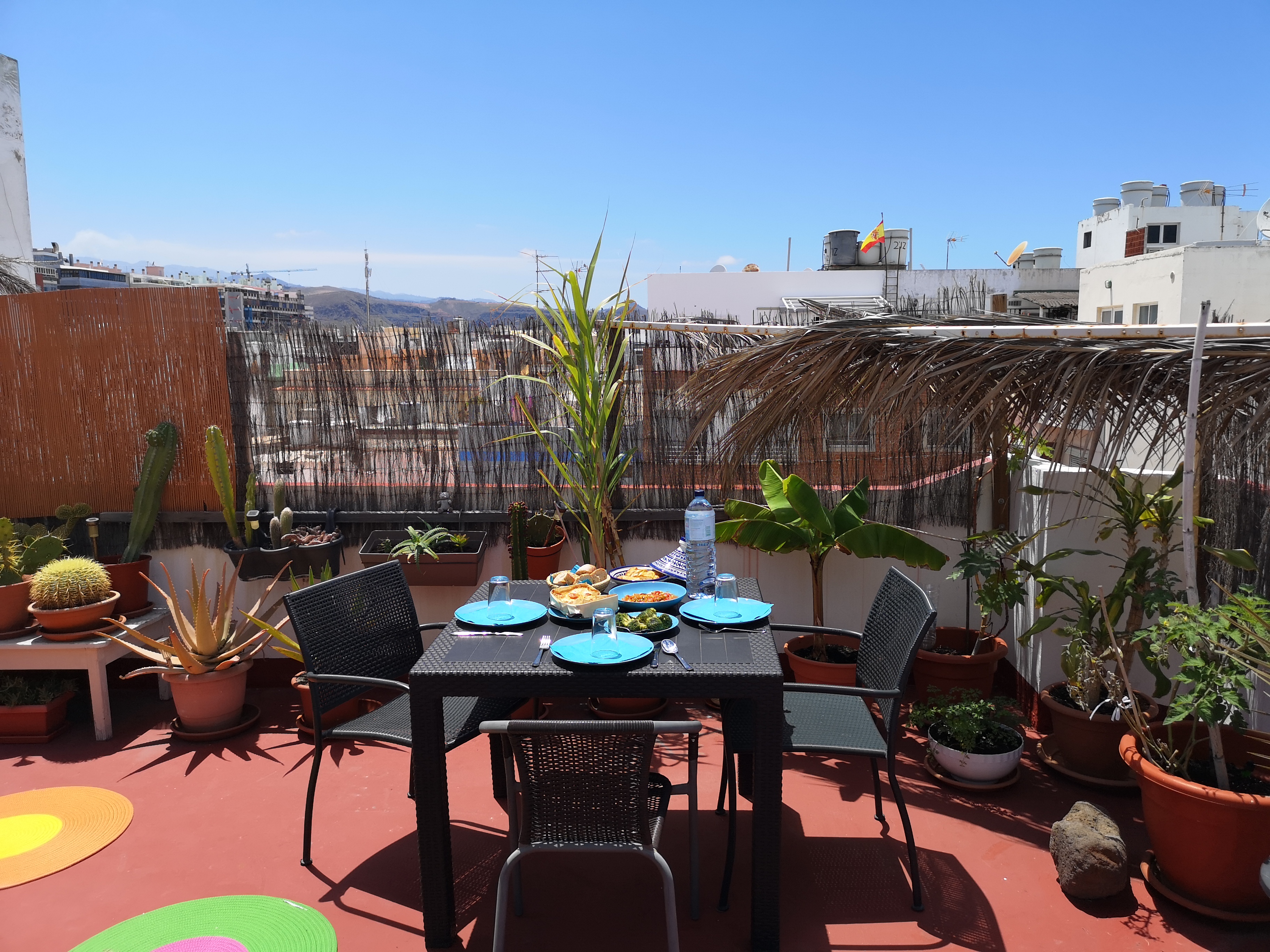 Bright shared terrace with dining area and open city views